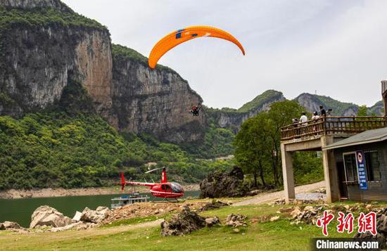 图为游客乘坐滑翔伞欣赏乌江峡谷风光。史开心 摄