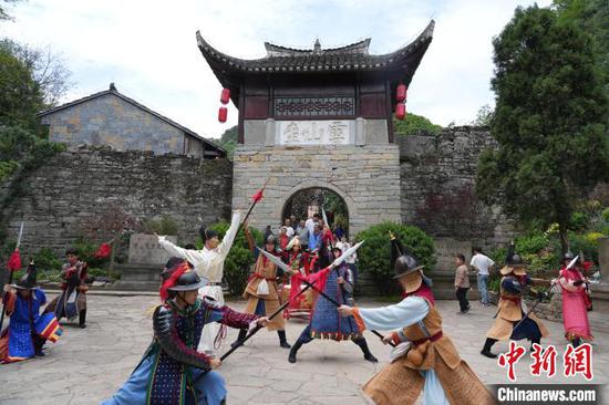 图为游客在云峰屯堡景区体验“音乐开屯门”活动。石小杰 摄