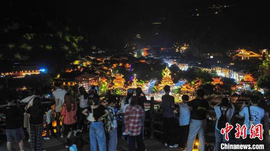 5月1日晚,游客在贵州省黎平县肇兴侗寨观赏侗寨夜景。卢忠南 摄 5月1日晚,游客在贵州省黎平县肇兴侗寨观赏侗寨夜景。卢忠南 摄