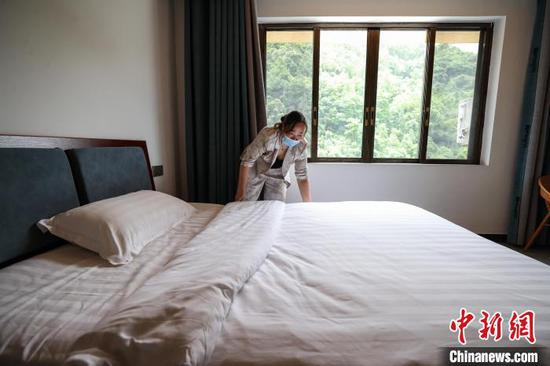 5月2日,遵义市绥阳县温泉镇公平村的村民陈英在收拾民宿客房。 中新社记者 瞿宏伦 摄 5月2日,遵义市绥阳县温泉镇公平村的村民陈英在收拾民宿客房。 中新社记者 瞿宏伦 摄