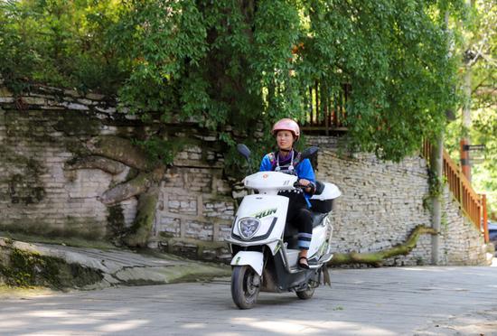 ↑ 4月19日，陈星星在下院村给村民送豆腐。