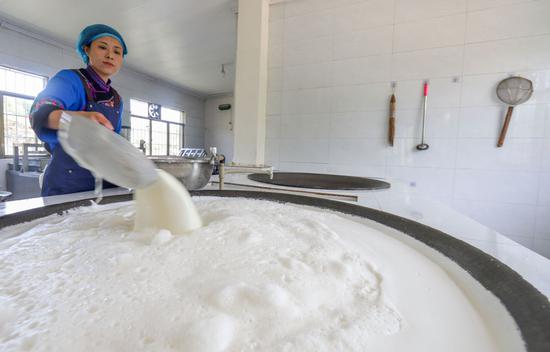 ↑ 4月25日，陈星星在作坊内煮豆浆。