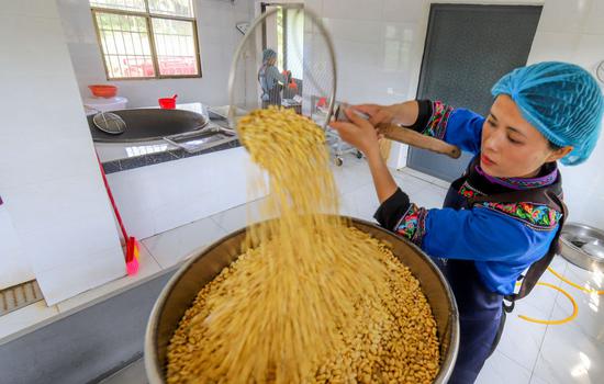 ↑ 4月25日，陈星星将大豆放入榨浆机。