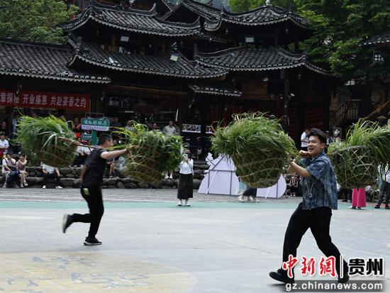 图为西江千户苗寨游客在挑战挑草接力赛 图为西江千户苗寨游客在挑战挑草接力赛