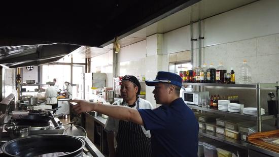 消防监督员搜检饭店抽油烟机浑洗环境 刘晓卫 摄