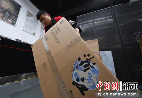 图为:工作人员搬运印有浙江文化LOGO的快递箱。中新社记者 王刚 摄
