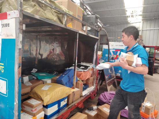 5月1日，赵松在赫章县中通快递公司仓库装货，准备派送。刘虹艳 摄
