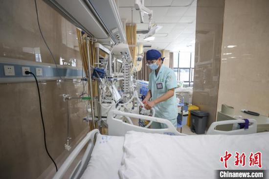 图为李学建在准备呼吸机。中新社记者 瞿宏伦 摄