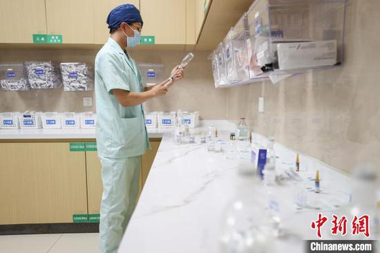 图为李学建在治疗室配药。中新社记者 瞿宏伦 摄