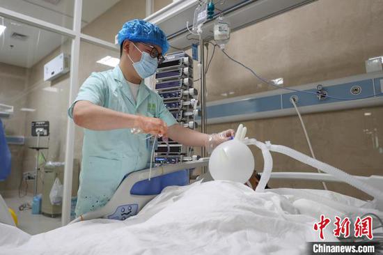 图为黄旗文在为患者吸痰。中新社记者 瞿宏伦 摄