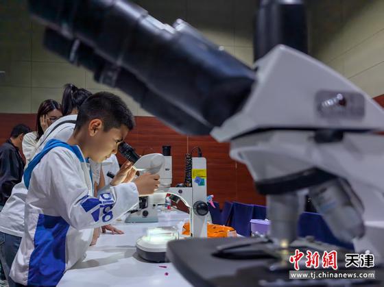  5月17日，中国科学院天津工业生物技术研究所举行了以“生物制造启未来”为主题的公众科学日活动。900余名中小学生及社会公众走进研究所，共同探索生物制造的奥秘。图为少年儿童通过显微镜观察各种菌体。记者 佟郁 摄
