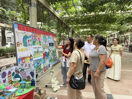 工作人员以孩子们的手抄报为载体,向市民科普垃圾分类知识。黄文娟 摄。