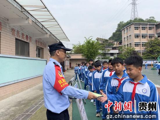 图为派出所工作人员发放宣传手册 李明菲摄