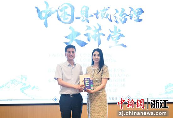 图为:中国新闻社浙江分社党委书记、社长柴燕菲为中共德清县委书记王波赠书。中新社记者 王刚 摄