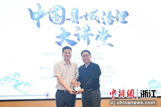 图为:浙江大学社会治理研究院副院长、浙江大学马克思主义学院副院长陈宝胜向中共德清县委书记王波赠送纪念品。中新社记者 王刚 摄