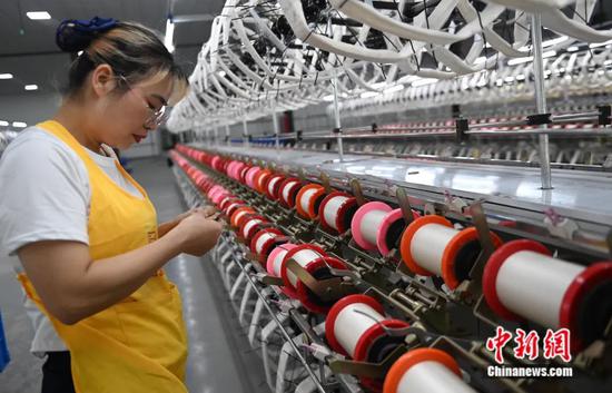 图为民众在现代化纺织绸厂工作。蒋雪林 摄
