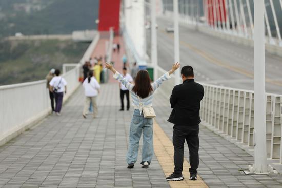 游客与龙里河大桥合影