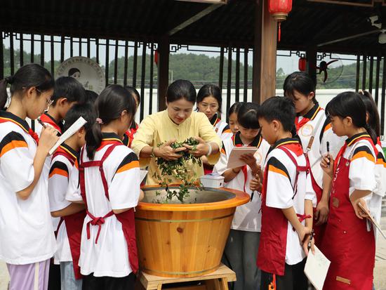 图为冯康玲向学生展示制茶技艺。被访者供图 图为冯康玲向学生展示制茶技艺。被访者供图