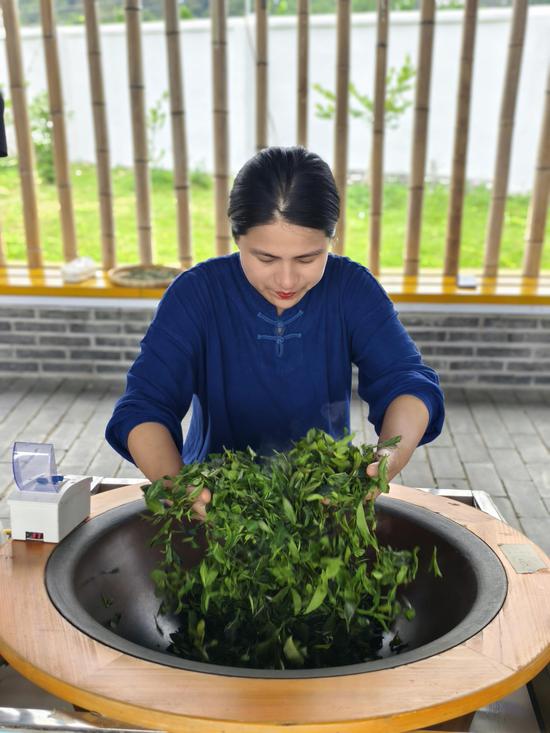 图为冯康玲正在对茶叶进行杀青。被访者供图 图为冯康玲正在对茶叶进行杀青。被访者供图