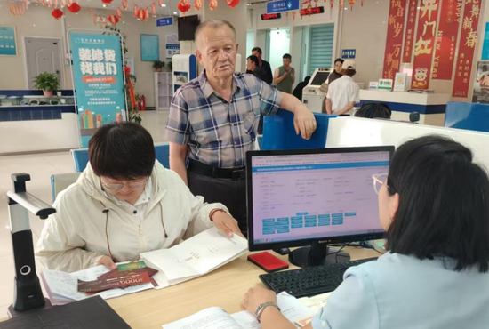 图为客户在克州农商银行柜台办理住房公积金贷款业务。
