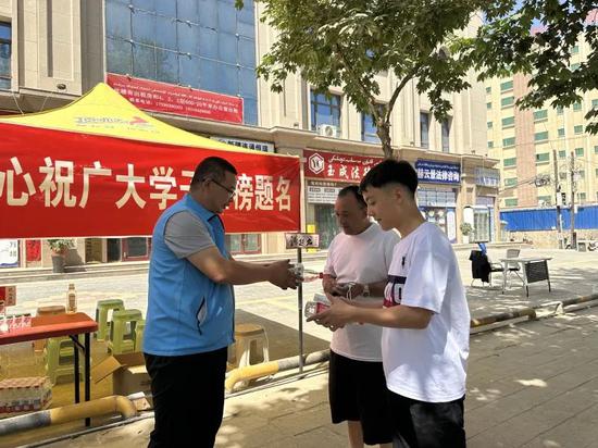 中国体育彩票和田分中心的工作人员为考生和家长送上纸巾和饮用水。宋俞霖 摄