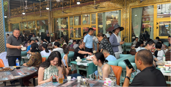 火焰山镇的黄面烤肉店座无虚席,游客络绎不绝,热闹非凡。黄文娟 摄