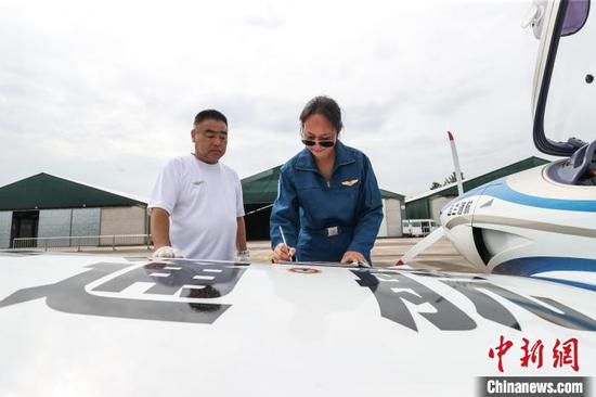 6月10日，韩玉(右)在黄平旧州机场做起飞前准备工作。中新社记者 瞿宏伦 摄