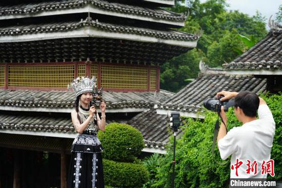 图为6月11日，游客在贵州肇兴侗寨拍摄艺术照。石小杰 摄