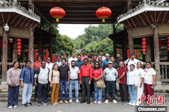 6月13日，高级干部考察团在黔东南州黎平县肇兴侗寨合影。6月12日至15日，斯里兰卡人民解放阵线总书记蒂尔文·席尔瓦率领的高级干部考察团一行参访贵州，来到贵阳市、黔东南州部分区县，了解贵州在脱贫攻坚、数字经济、生态环保等方面情况。中新社记者 瞿宏伦 摄