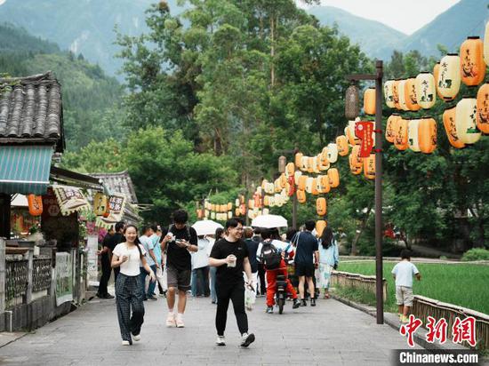 6月15日，游客在贵州省江口县云舍村游玩，乐享惬意时光。中新社记者 周燕玲 摄