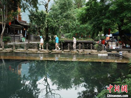 6月15日，游客在贵州省江口县云舍村游玩，乐享惬意时光。中新社记者 周燕玲 摄