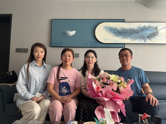 护士于敏洁(左一)、主管医生张文(左二)、惠志医生(右一)到患者李女士(右二)家中家访。(郑雨晴 摄)e
