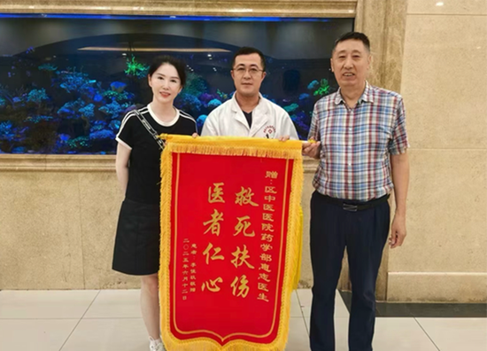 患者李女士(左一)与惠志医生(中)、药学部副主任张砾岩(右一)合影。(丁伟摄)