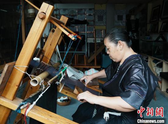 图为6月19日龙女三九在工作室内织布。 图为6月19日龙女三九在工作室内织布。