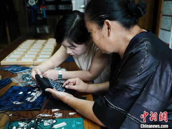 6月16日,龙女三九和女儿陈艳在讨论锡绣如何与耳饰更好地结合起来。 6月16日,龙女三九和女儿陈艳在讨论锡绣如何与耳饰更好地结合起来。