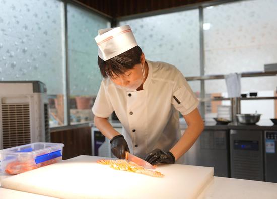 6月19日,高昌区火洲冰焰三文鱼馆的工作人员在加工三文鱼。吐鲁番市融媒体中心记者 谢懂飞 摄 6月19日,高昌区火洲冰焰三文鱼馆的工作人员在加工三文鱼。吐鲁番市融媒体中心记者 谢懂飞 摄