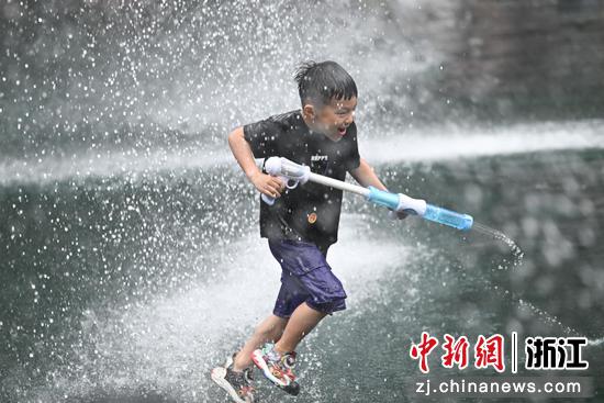 图为：小朋友体验泼水活动。中新社记者 王刚 摄