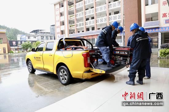 6月21日,南丹供电公司抢修人员将应急发电机送抵受灾学校。艾晓山 摄