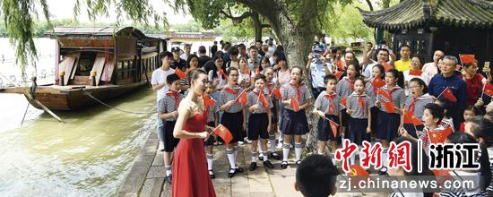 浙江嘉兴南湖湖心岛，少先队员们在红船旁合唱。王振宇摄