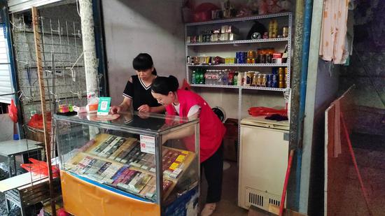 图为帮扶队员帮助受灾商户整理店面。王琪 摄 图为帮扶队员帮助受灾商户整理店面。王琪 摄