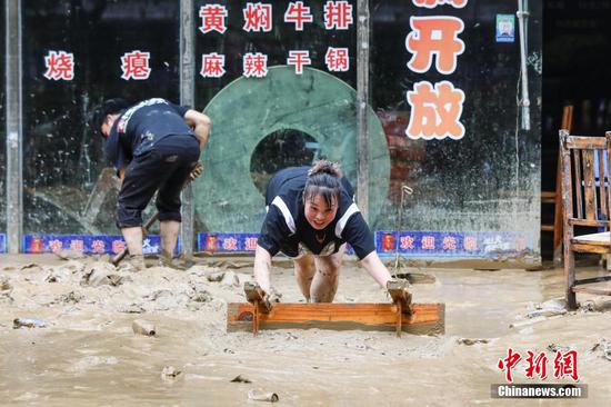 6月25日，榕江县城居民在清理淤泥。6月24日凌晨，受持续强降雨及上游来水叠加影响，贵州省黔东南苗族侗族自治州榕江县境内多条河流水位持续快速上涨，遭遇特大洪水，县城多处低洼地带被淹。险情发生后，当地迅速响应，全力开展抢险救灾工作。目前，榕江县城洪水已逐步退去，清淤清障工作有序开展，电力、供水、通讯等基础设施正抓紧抢修。