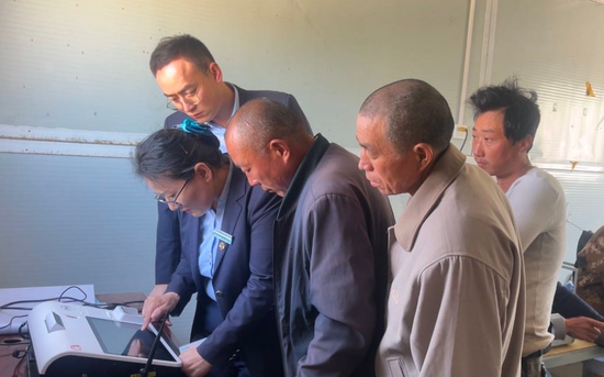 图为6月13日,哈巴河县农信社工作人员在建设工地为工友们办理工资卡。常珊 摄 图为6月13日,哈巴河县农信社工作人员在建设工地为工友们办理工资卡。常珊 摄
