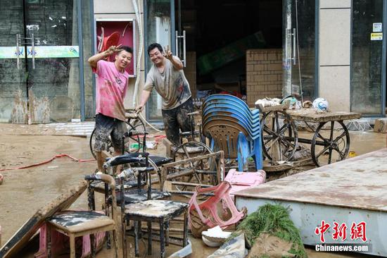 6月25日，榕江县城居民在清理杂物时对着镜头比耶。6月24日凌晨，受持续强降雨及上游来水叠加影响，贵州省黔东南苗族侗族自治州榕江县境内多条河流水位持续快速上涨，遭遇特大洪水，县城多处低洼地带被淹。险情发生后，当地迅速响应，全力开展抢险救灾工作。目前，榕江县城洪水已逐步退去，清淤清障工作有序开展，电力、供水、通讯等基础设施正抓紧抢修。