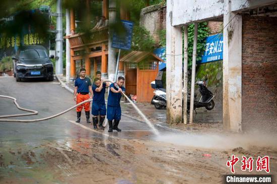6月25日，从江县城区，党员和干部群众用水枪清洗街道。吴德军 摄