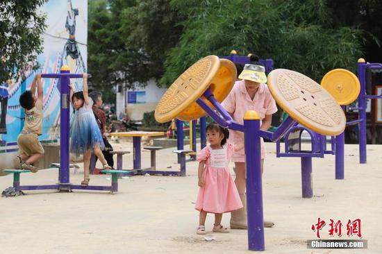 6月26日，孩童在榕江县城一广场玩耍。