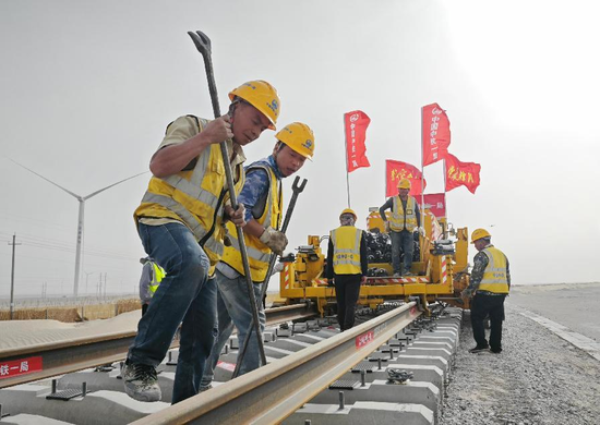6月23日,在罗布泊至若羌铁路米兰至罗布泊段现场,中铁一局罗若铁路SPJ标项目部党员带领建设者们开展辅轨作业。郭城 摄 6月23日,在罗布泊至若羌铁路米兰至罗布泊段现场,中铁一局罗若铁路SPJ标项目部党员带领建设者们开展辅轨作业。郭城 摄