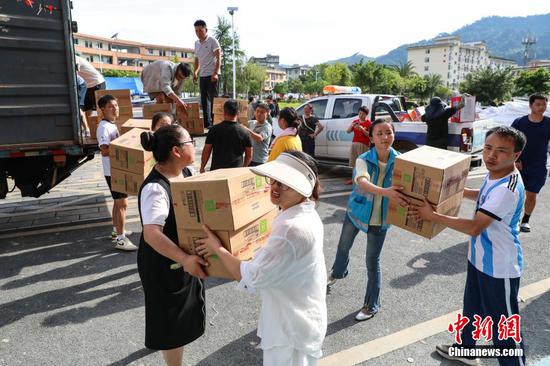 6月26日，工作人员在转移各方捐赠的救援物资。