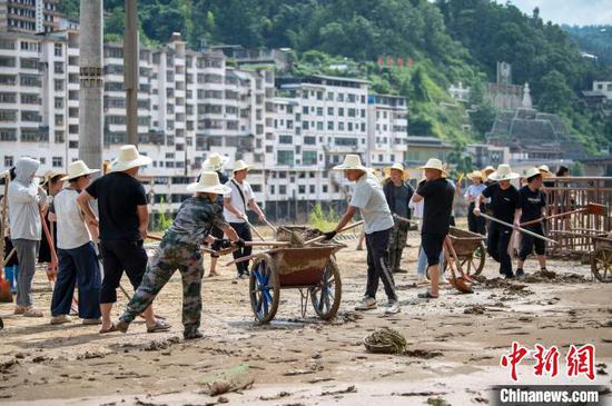 6月25日，从江县城区，党员和干部群众齐力清理街道淤泥。吴德军 摄