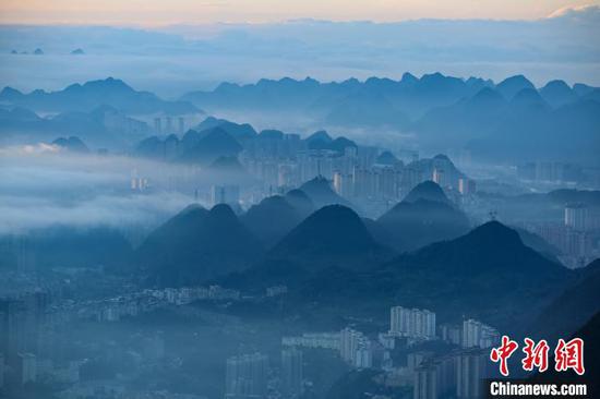 6月28日清晨，贵州六盘水市雨后放晴，呈现出别样美景。连日来，该市连续降雨，当日转晴后，从梅花山旅游景区俯瞰六盘水市区，青翠山岭间，云海依着山势涌动。赵桦 摄