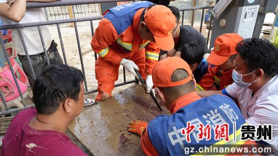 图为台江县梅影路消防救援站田明江正在救助手被钉子钉住的小孩。